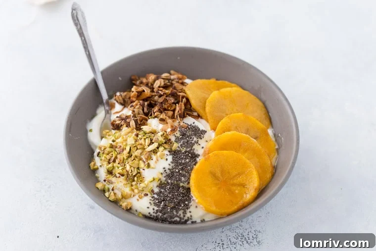 An overhead shot of a delightful roasted persimmon yogurt bowl, showcasing the various textures and colors of the ingredients, ready to be enjoyed.