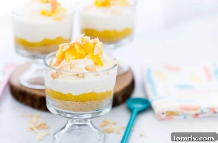 Close-up view of a layered Coconut Mango Mousse cup, showcasing the creamy mousse, vibrant mango puree, and crunchy shortbread cookie base