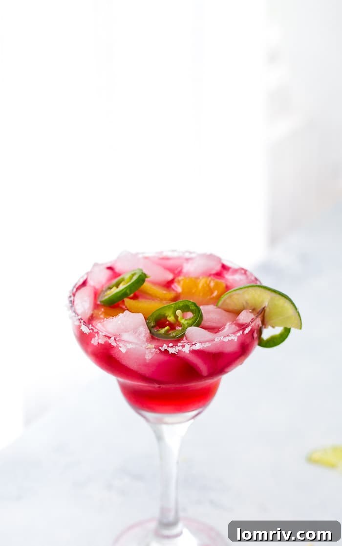 Three Hibiscus Margaritas with Pineapple and Jalapeño, beautifully presented in salt-rimmed glasses, ready for enjoyment.