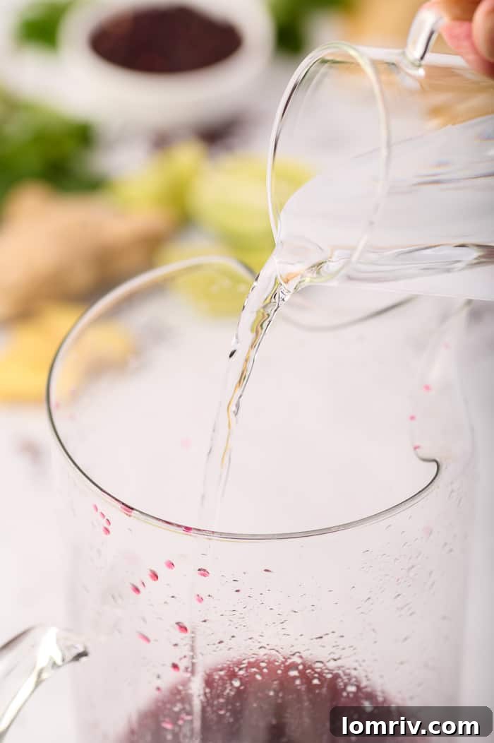 Pouring Sparkling Water into Hibiscus Drink