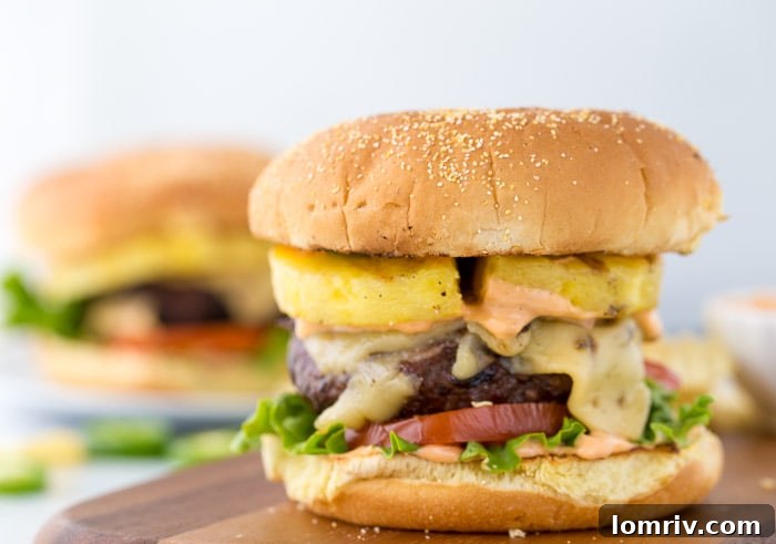 Close-up of a perfectly cooked Pineapple Jalapeno Burger, showcasing the grilled pineapple, jalapenos, and melted cheese.