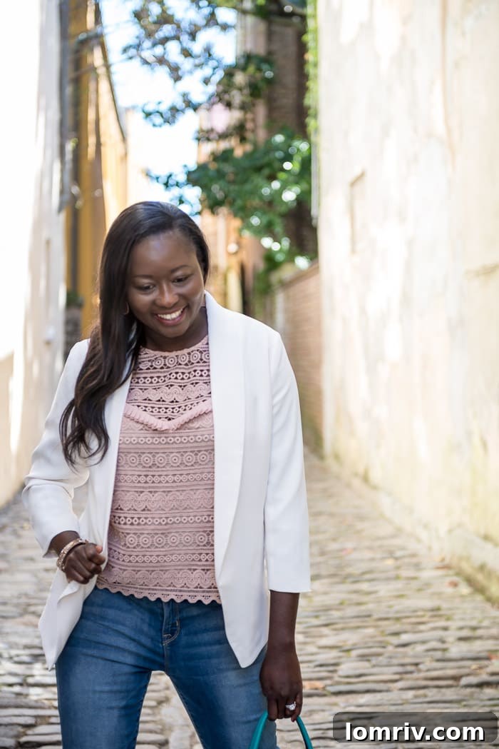 Stylish blogger wearing a white blazer, lace top, and jeans, perfect for a chic evening look.