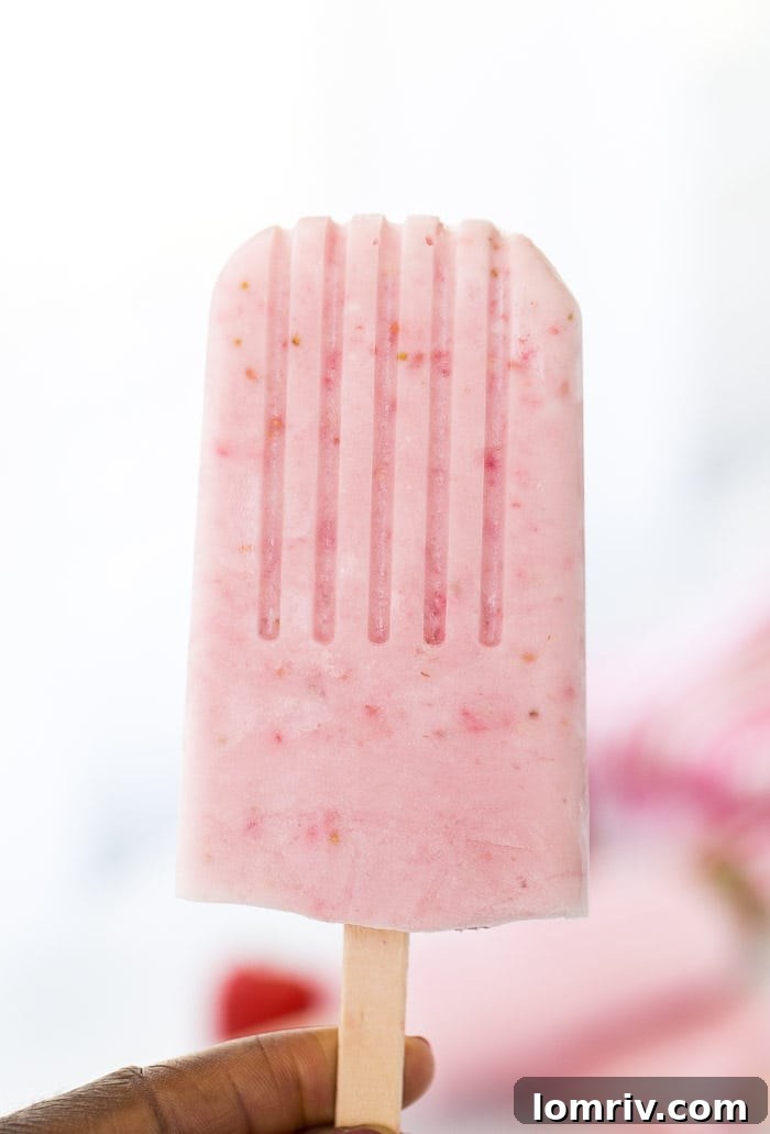 Experience pure summer bliss with homemade Strawberry Coconut Cheesecake Popsicles - easy to make, incredibly delicious.