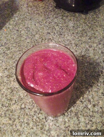 A vibrant and creamy paleo chocolate cherry smoothie in a clear glass, perfect for a healthy dessert or snack.