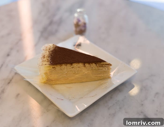 A beautiful slice of crepe cake from Millie's Patisserie, showing its many delicate layers and light cream, a refined dessert option in Toronto.