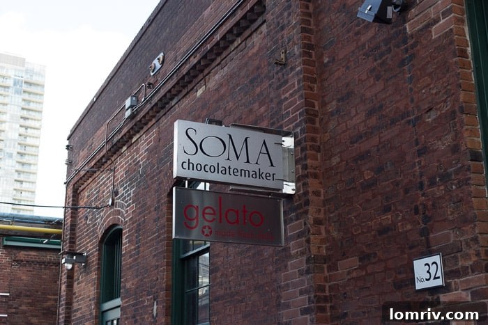 A steaming cup of rich hot chocolate from Soma Chocolatemaker, enjoyed amidst the historic backdrop of Toronto's Distillery District.