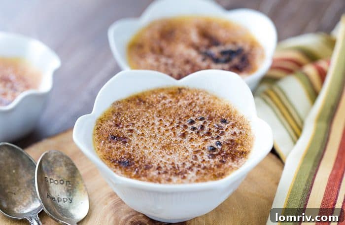 Close-up of three Honey Caramel Creme Brulees, showing the smooth custard and the perfectly torched, amber-colored topping