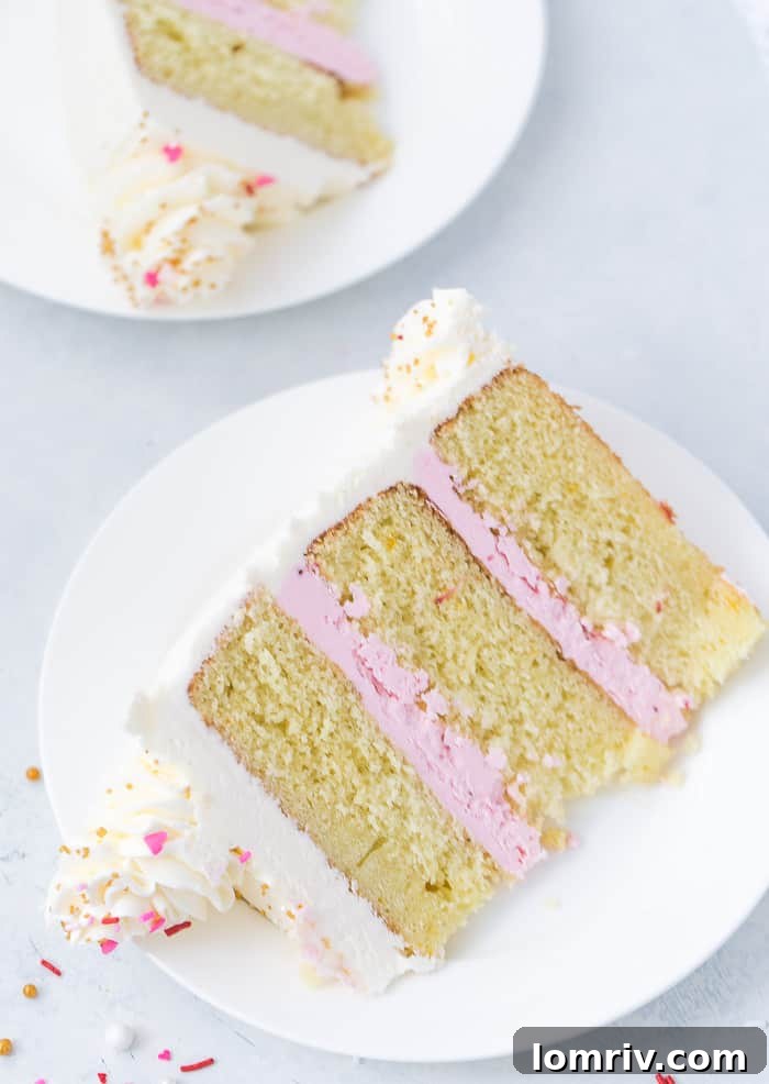 A close-up of a beautifully frosted Pink Champagne Cake, showcasing the smooth texture of the Swiss meringue buttercream.