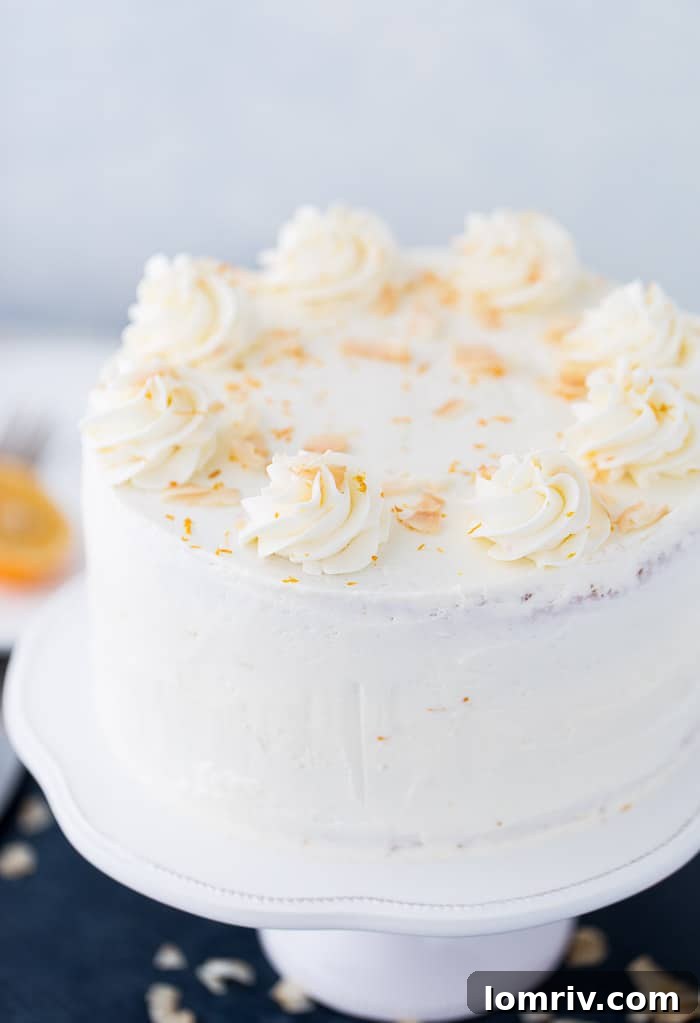 Beautifully frosted Meyer Lemon Coconut Cake on a serving plate
