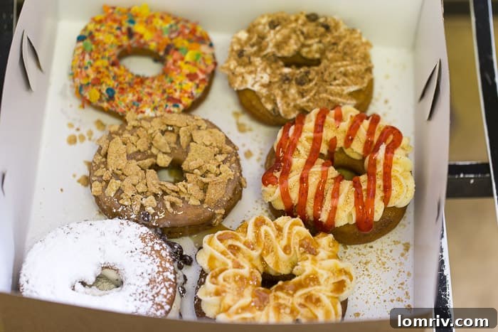 A captivating display of colorful and creatively customized doughnuts, highlighting the endless options at Just Donuts Syracuse.