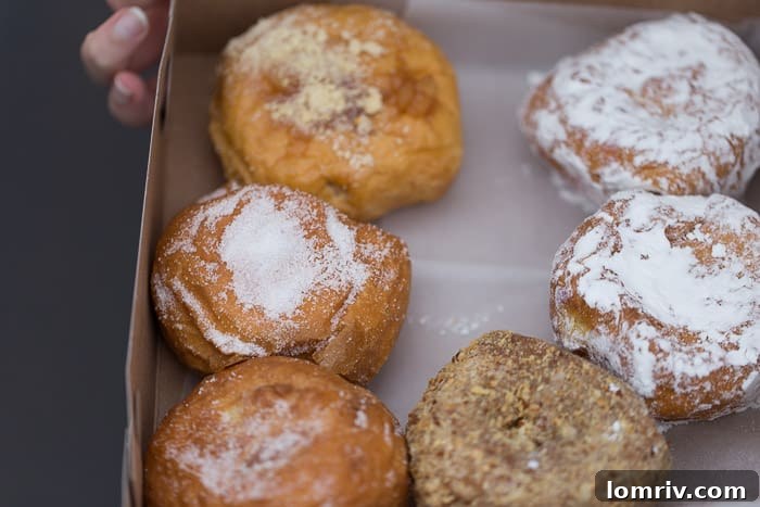 A delightful counter array of freshly baked goods and classic doughnuts, showcasing the charm of Harrison Bakery in Syracuse.