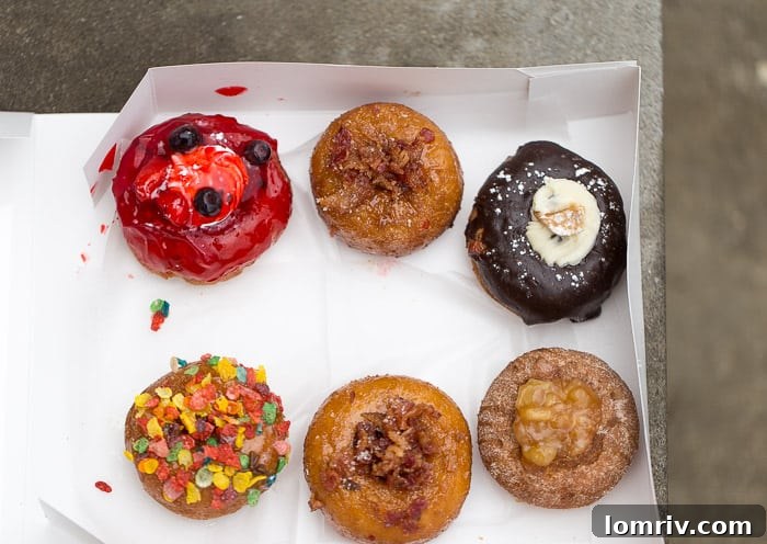 A diverse selection of unique gourmet doughnuts including Boom Boom Berry, Dizzy Pig, Holy Cannoli, Cereal Killer, and Sea Salt Caramel Apple, showcasing the creativity of Glazed and Confused in Syracuse.