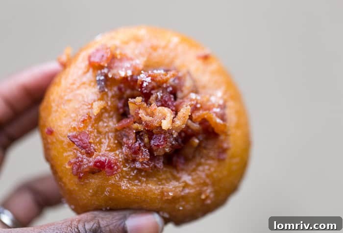 A close-up shot of the renowned Dizzy Pig doughnut, featuring candied bacon and a rich maple glaze, from Glazed and Confused Syracuse.