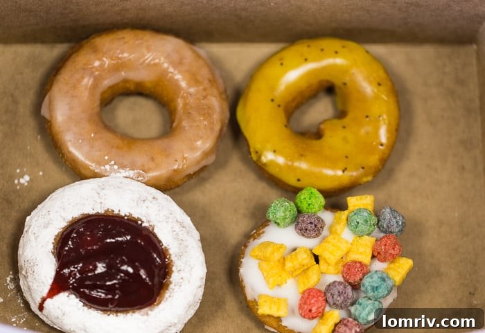 An appetizing array of classic and specialty doughnuts from Regional Donut Authority, featuring old-fashioned vanilla glazed, vibrant lemon poppyseed, sweet jelly filled, and crunchy cereal crunch options.