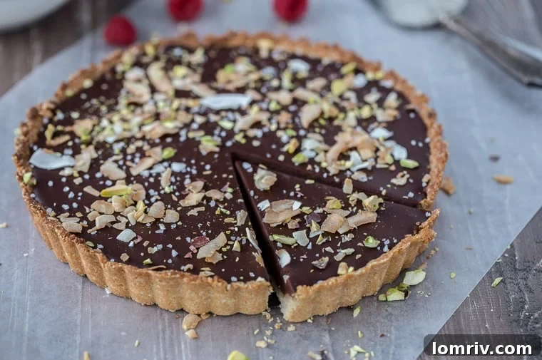 A decadent gluten-free and vegan chocolate coconut tart that starts with a chewy coconut almond crust and is filled with creamy chocolate coconut ganache.