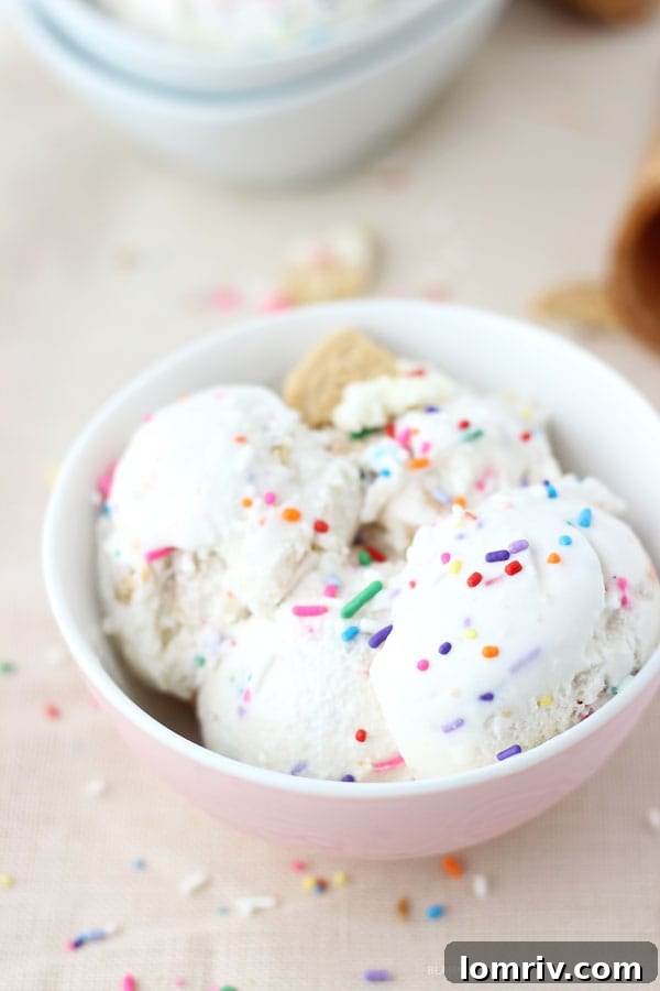 Overhead shot of Funfetti Golden Oreo Ice Cream in a white bowl with a spoon, ready to be eaten