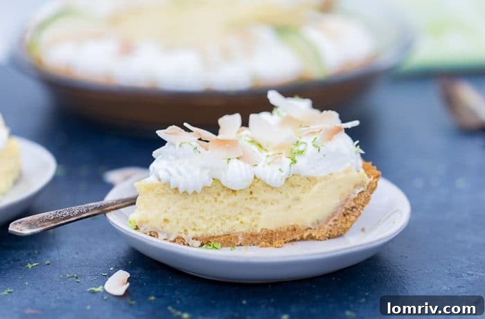 A full Coconut Key Lime Pie, garnished with whipped cream and toasted coconut.