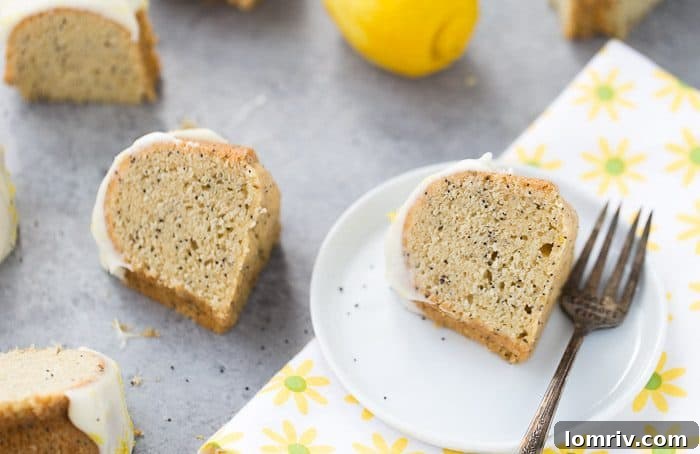Close-up shot of a slice of moist lemon poppy seed bundt cake revealing its light texture and poppy seeds.