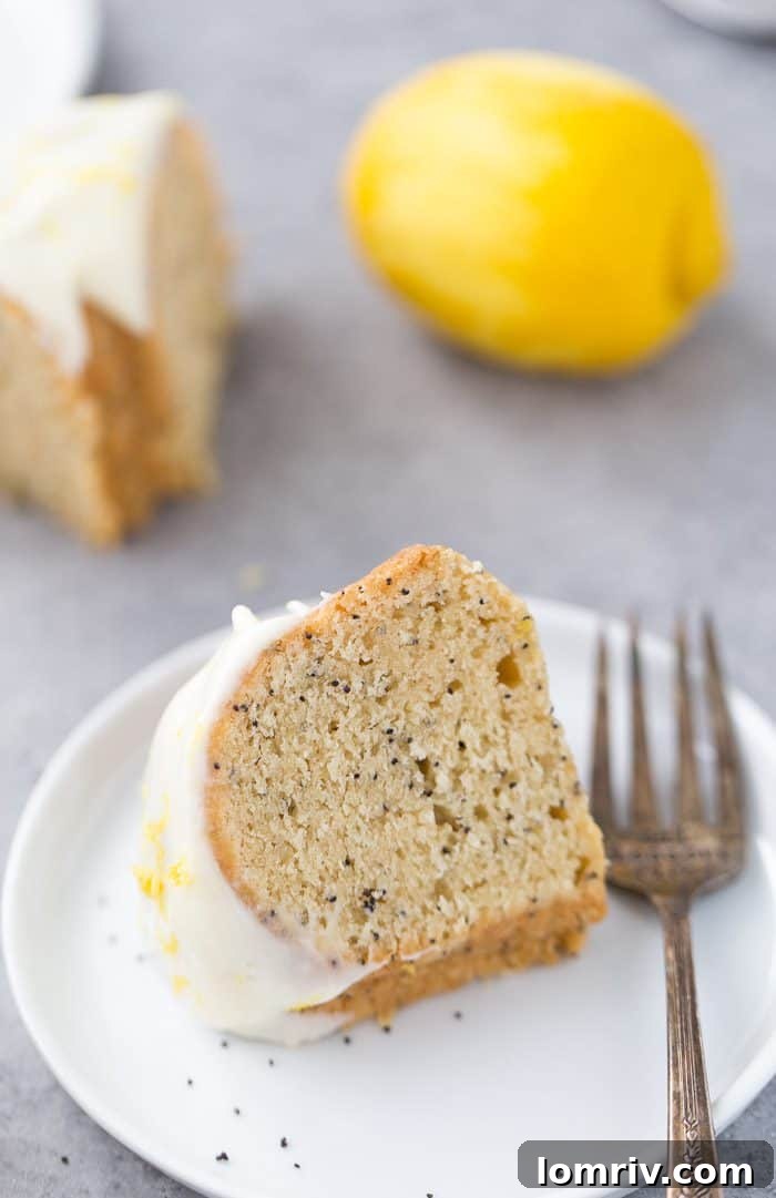 Lemon poppy seed bundt cake with a generous lemon glaze drizzled over it, ready to serve.