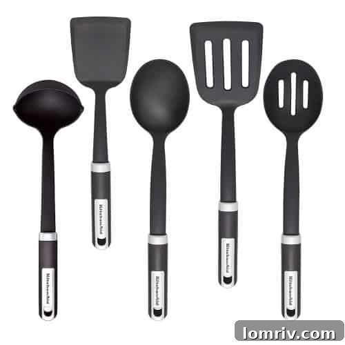 An organized collection of kitchen utensils in a holder, including spatulas, whisks, and ladles, ready for various cooking tasks.