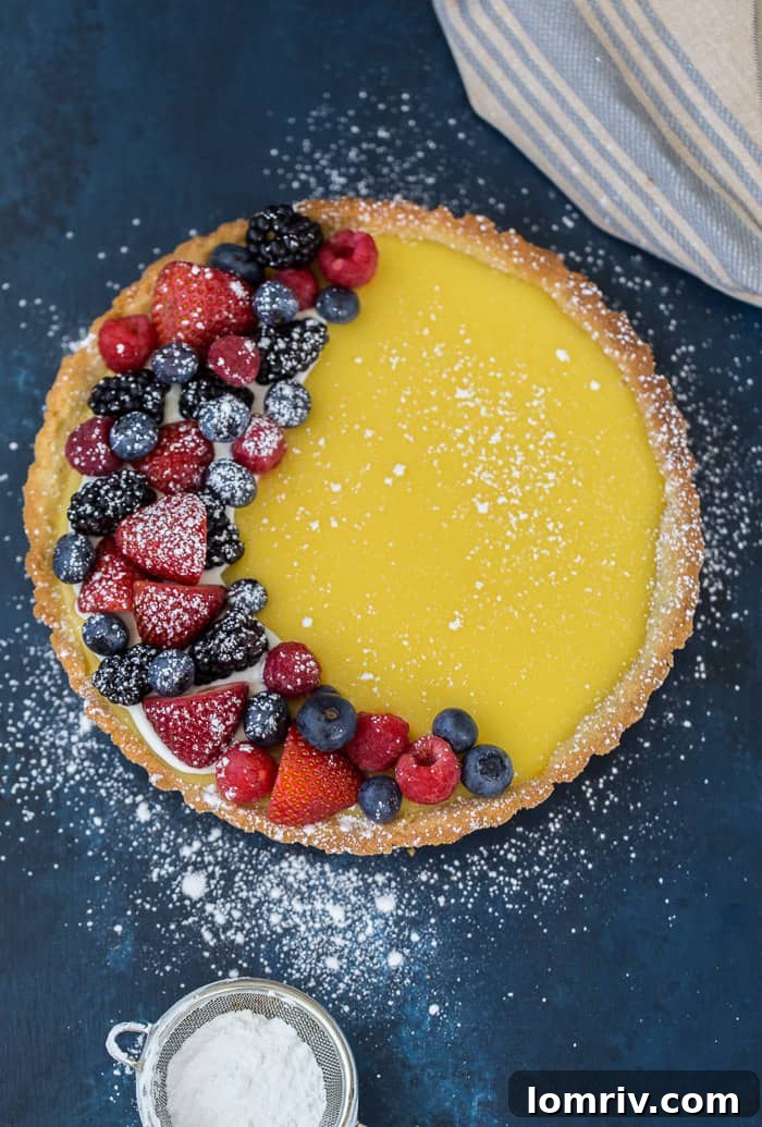 Three Classic Lemon Tarts on a Table with Berries