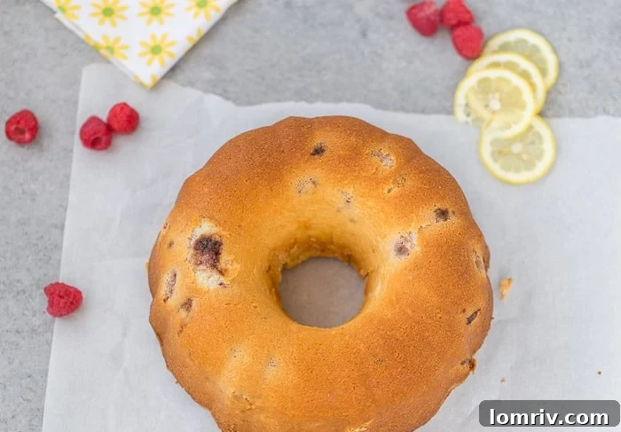 Slice of Raspberry Lemonade Pound Cake on a plate with fresh berries