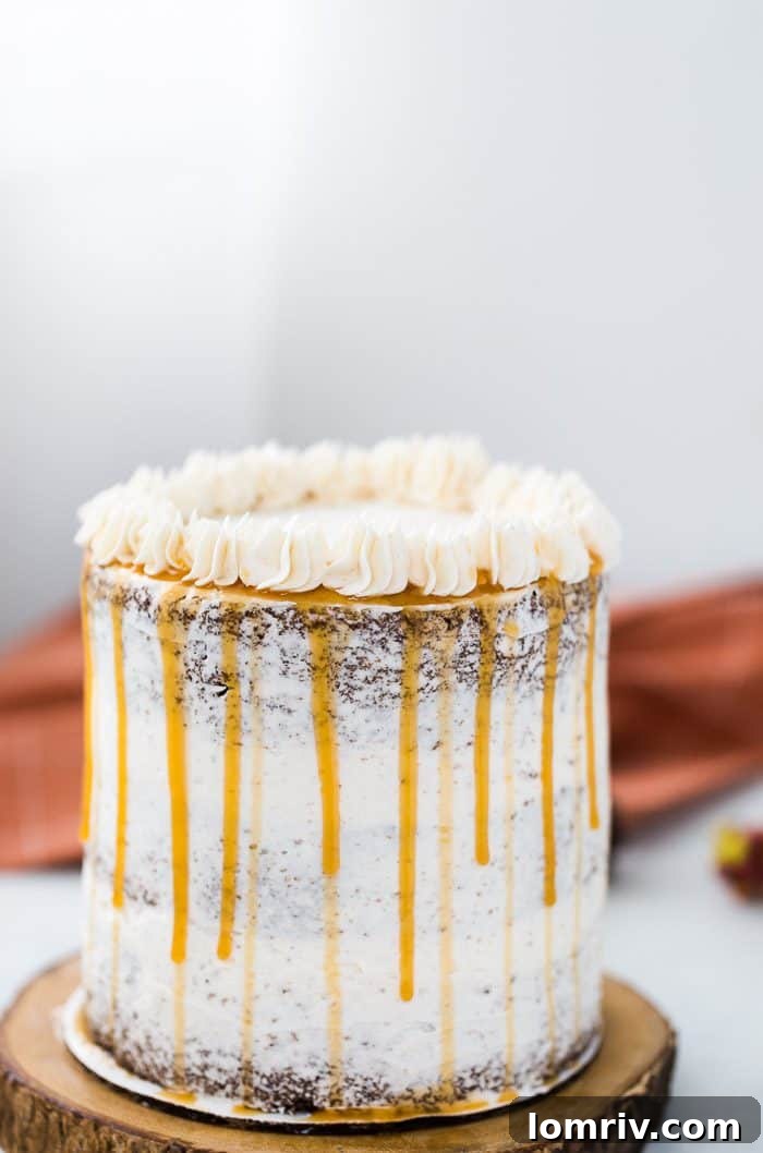 Delicious apple spice layer cake with creamy cinnamon frosting, garnished with caramel drizzle, perfect for autumn and holiday gatherings.