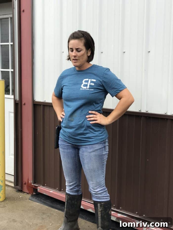 Kellie Blair, a modern farmer's wife, standing confidently on her century farm, embodying dedication and progress.