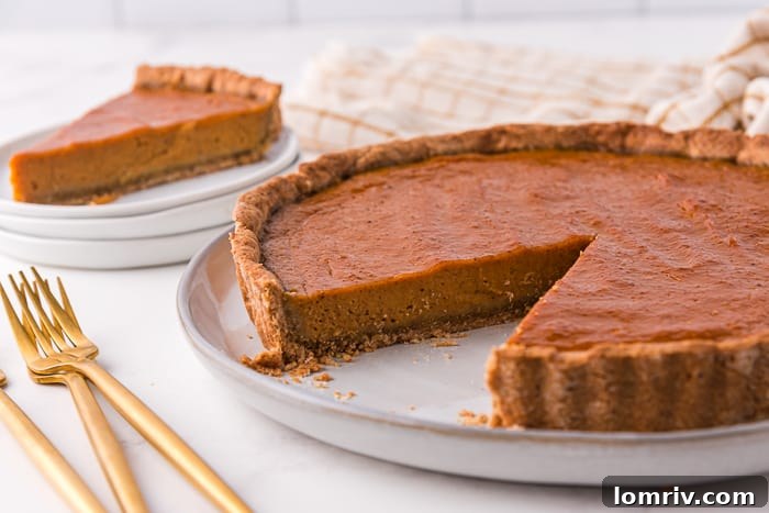 Pumpkin tart with a slice cut out of it.