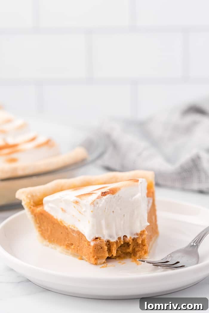 Slice of Sweet Potato Pie with perfectly gooey, toasted Maple Marshmallow Topping on a white plate