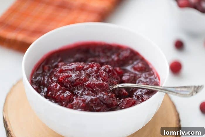 Close-up of fresh cranberries, orange, and brown sugar, key ingredients for a homemade cranberry sauce