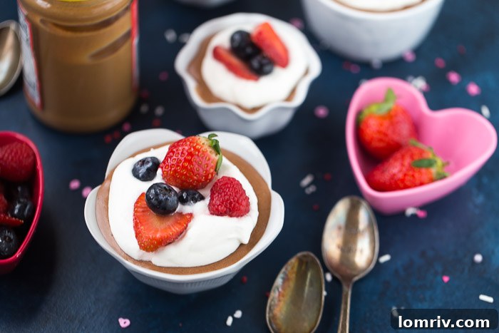 Close-up of a beautifully layered Peanut Butter Chocolate Mousse with a spoon, highlighting its creamy texture.