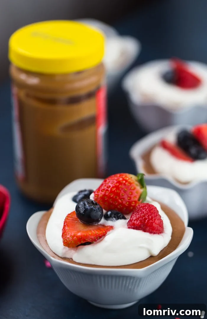 Individual servings of Peanut Butter Chocolate Mousse with a topping of fresh berries and whipped cream.