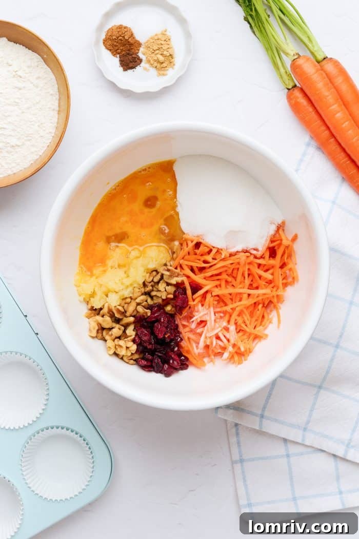 A white mixing bowl containing all the wet ingredients for the carrot cake cupcake batter.