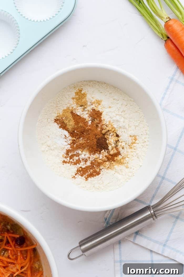 A white mixing bowl filled with the dry ingredients for carrot cake cupcakes.