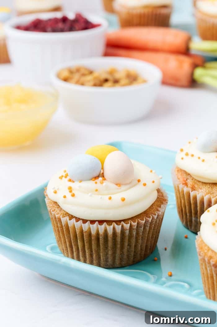 Decorated carrot cake cupcakes arranged appealingly on a blue plate.