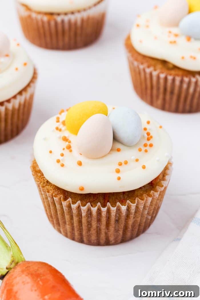 A trio of beautifully decorated carrot cake cupcakes.