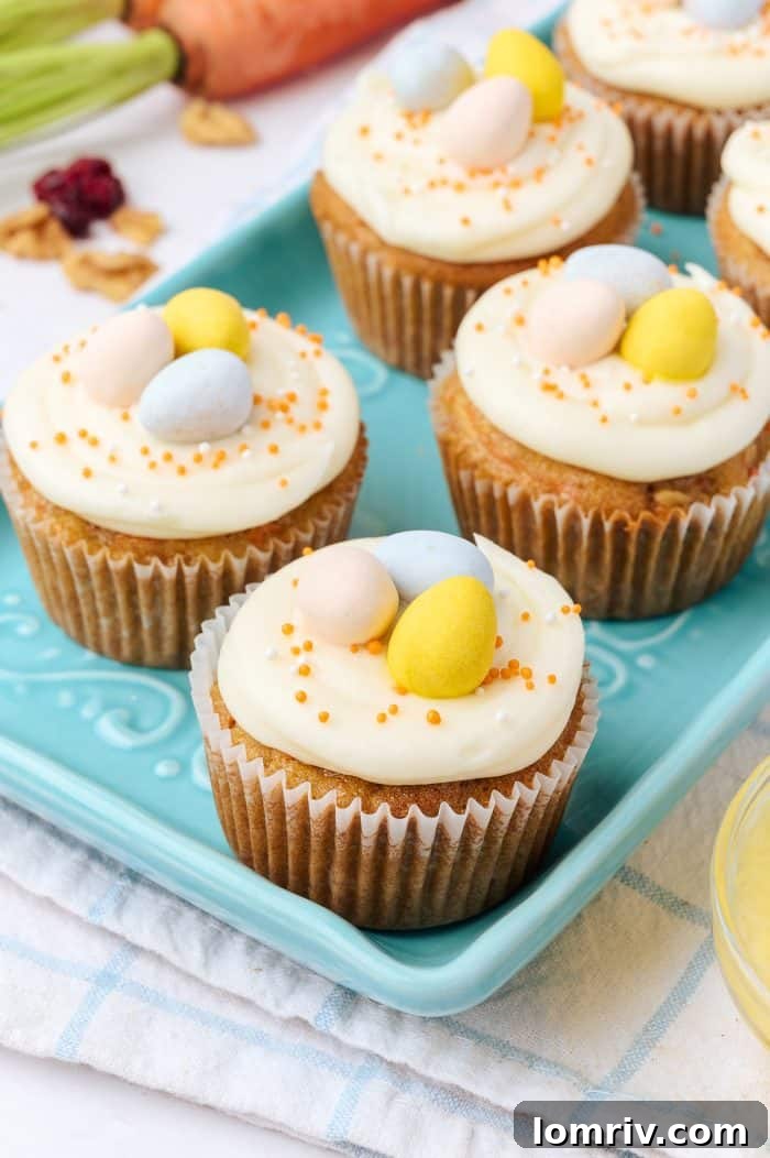 Decorated carrot cake cupcakes presented on a charming blue plate.