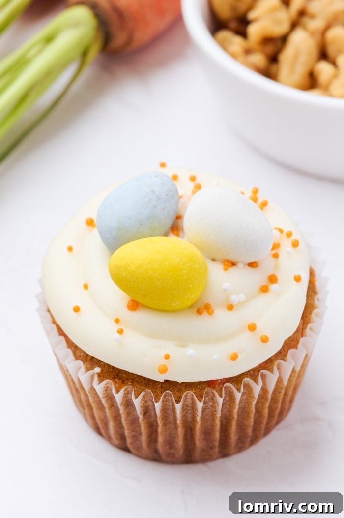 A perfectly decorated carrot cake cupcake, ready to be enjoyed.