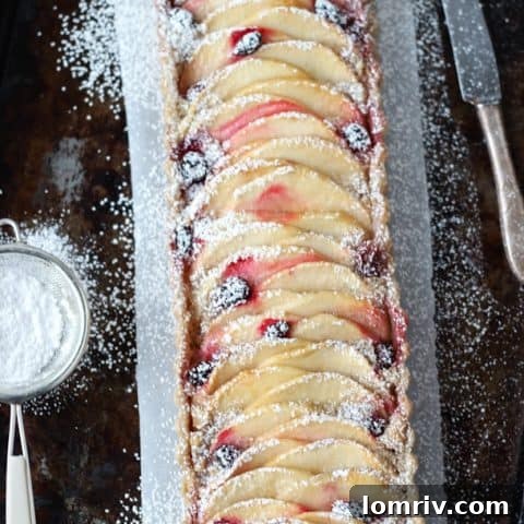 A gluten-free apple almond tart with cranberries, perfect for holidays.