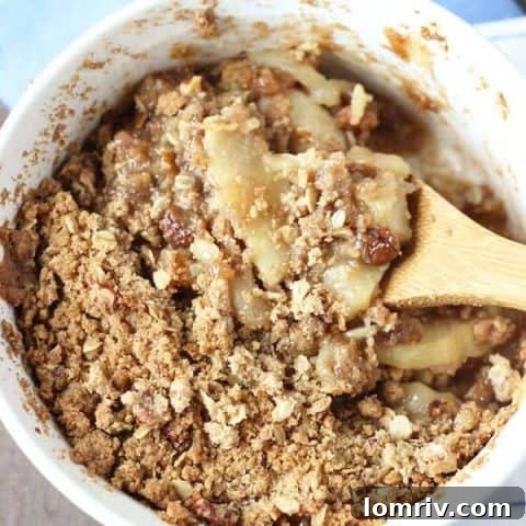 Warm spiced apple cardamom crisp topped with a nutty oat streusel and ice cream.