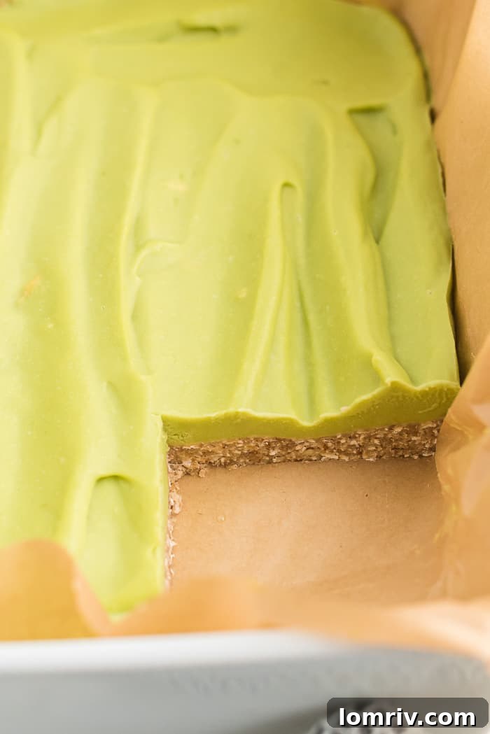 A stunning stack of Skinny Vegan Key Lime Pie Bars, garnished with fresh lime slices, ready to be devoured, highlighting their irresistible layers and vibrant color.