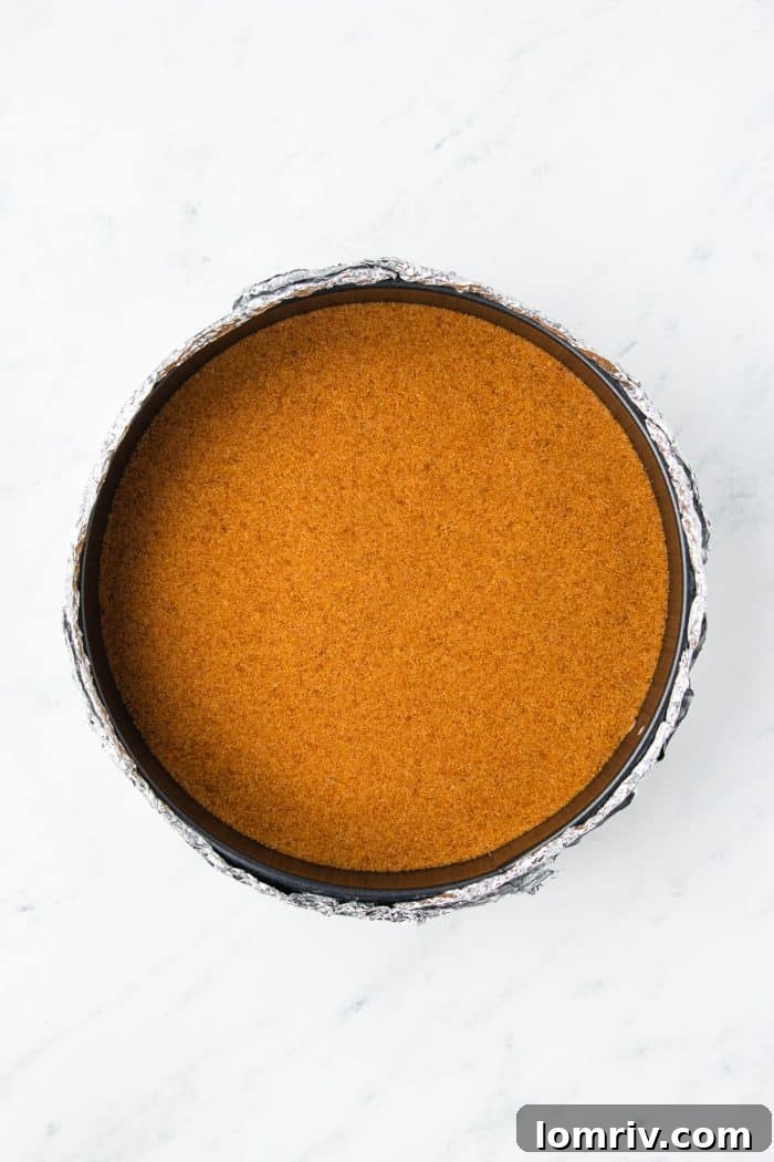 Gingersnap cheesecake crust pressed into a cheesecake pan.