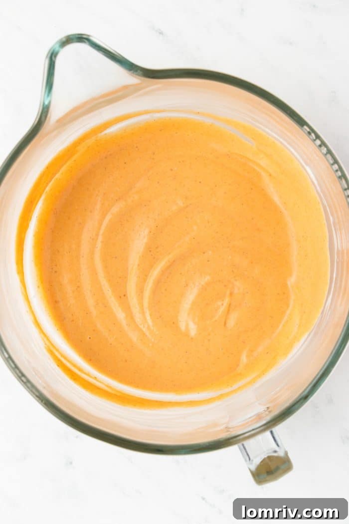 Canned pumpkin added to the remaining cheesecake batter in the mixing bowl.
