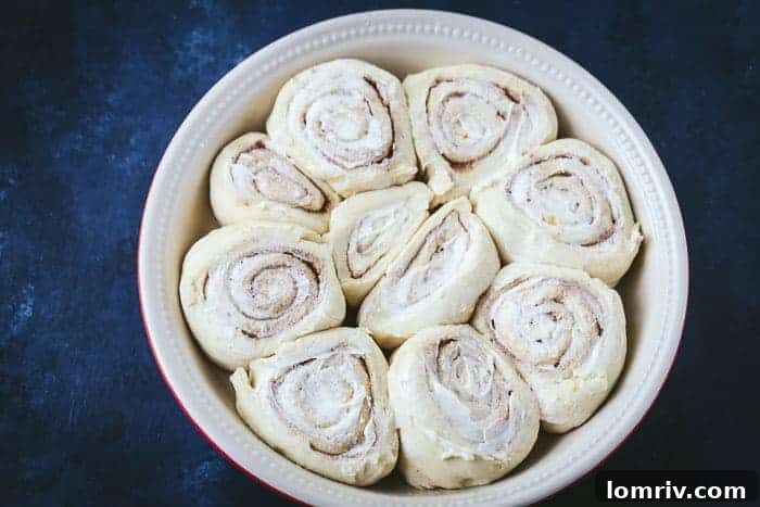 Brushing Eggnog Cinnamon Rolls with Melted Butter Before Baking