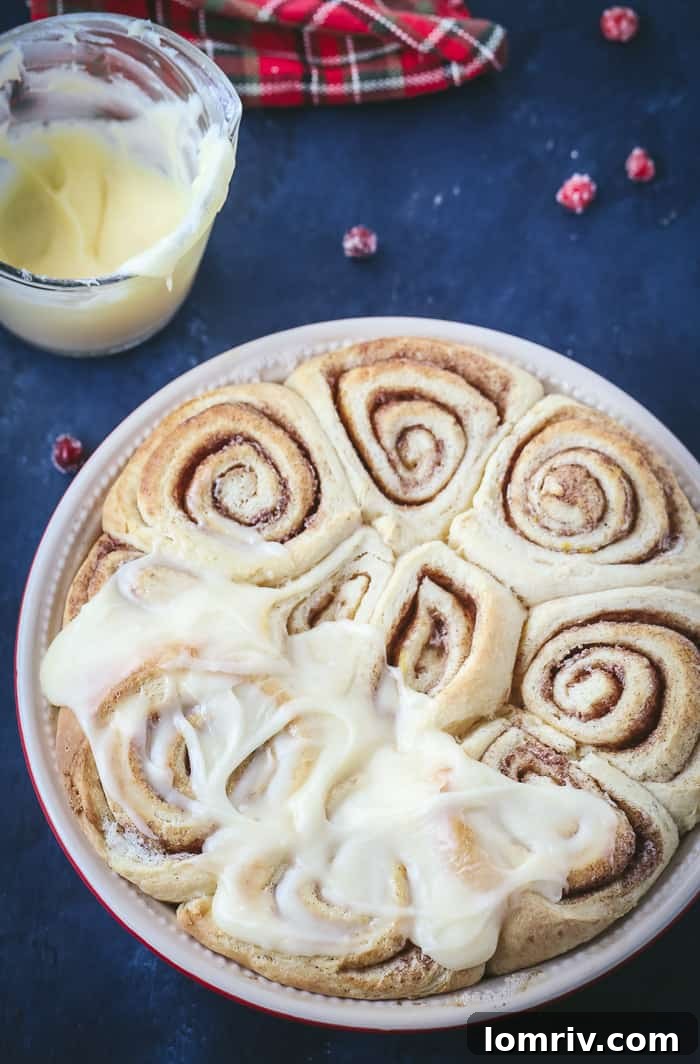 Spreading Creamy Eggnog Frosting on Warm Cinnamon Rolls
