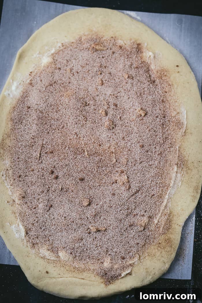 Sprinkling Cinnamon Sugar on Eggnog Cinnamon Roll Dough