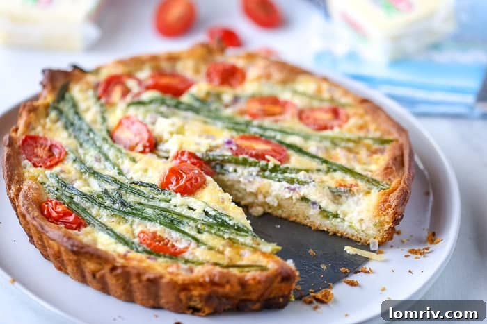 A close-up of a golden-brown Easy Asparagus Cheese Tart, showcasing its vibrant green asparagus and rich cheesy filling