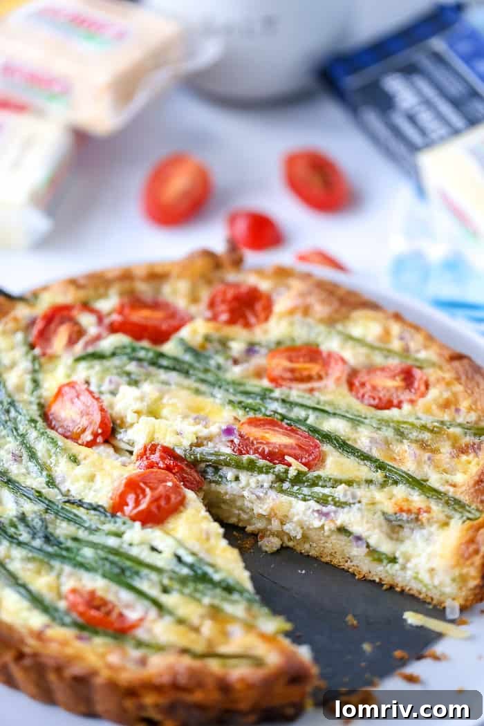A prepared Easy Asparagus Cheese Tart, showcasing the neatly arranged asparagus spears and cherry tomatoes before baking
