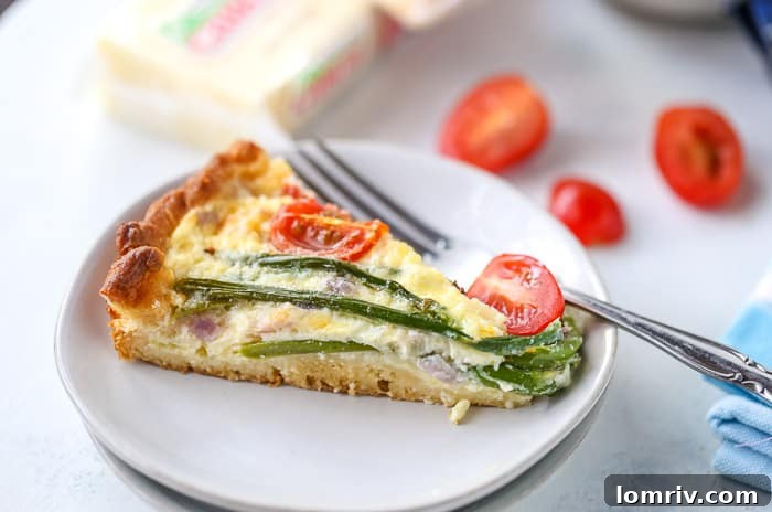 A perfectly baked slice of Easy Asparagus Cheese Tart on a white plate, ready to be enjoyed